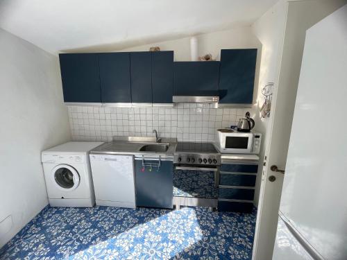 a small kitchen with a sink and a washing machine at La Cuchina in Capri