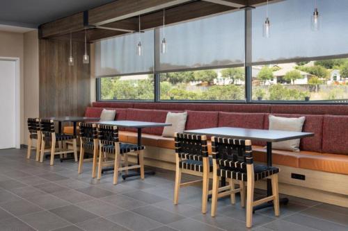 a restaurant with tables and chairs and a large window at Tru By Hilton San Antonio North in San Antonio