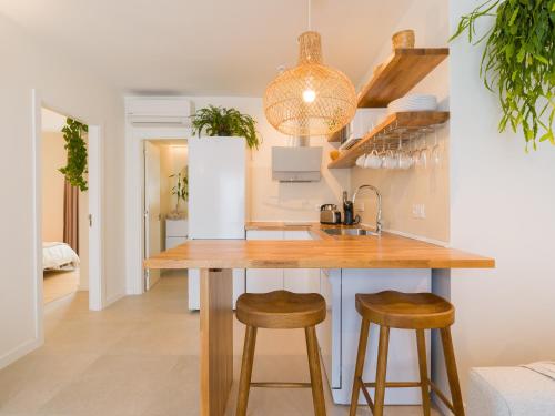 een keuken met een houten aanrecht en krukken bij Apartamento MOJO a 100mts de la playa de Corralejo in Corralejo