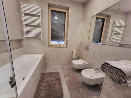 y baño con bañera, aseo y lavamanos. en Modern Living in Budapest en Budapest