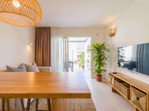een woonkamer met een houten tafel en een televisie bij Apartamento MOJO a 100mts de la playa de Corralejo in Corralejo