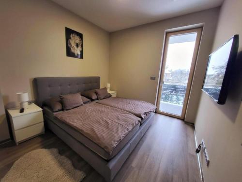 ein Schlafzimmer mit einem Bett und einem großen Fenster in der Unterkunft Modern Living in Budapest in Budapest