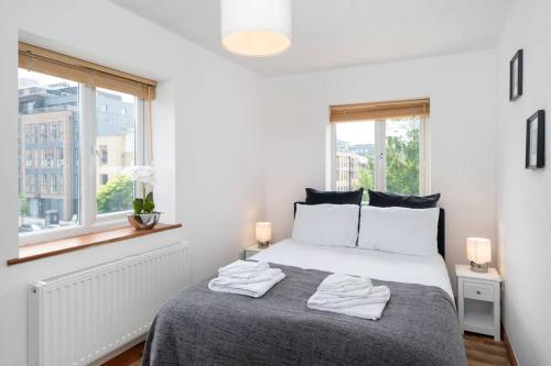 a bedroom with a bed with two towels on it at Omega - 3BD Gem in De Beauvoir Town in London