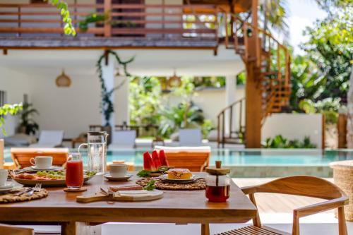 einen Tisch mit Speisen und Getränken neben einem Pool in der Unterkunft Vila Lion - Aldeia Jericoacoara Group in Jericoacoara