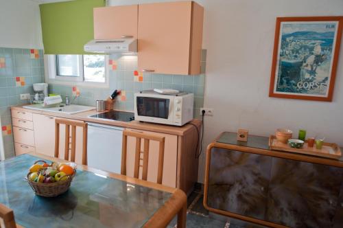 a kitchen with a table and a microwave at Résidence Villa Nova in Tiuccia