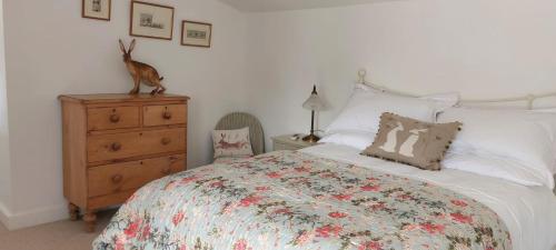 a bedroom with a bed with a deer statue on a dresser at Garden Cottage in heart of Kent in Kent