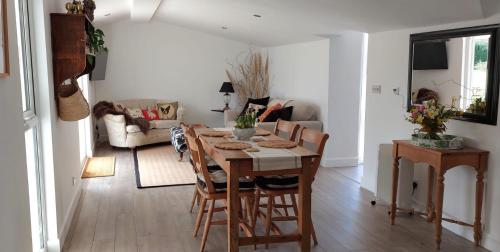 a living room with a wooden table and chairs at Garden Cottage in heart of Kent in Kent