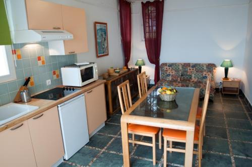 a kitchen and dining room with a table and chairs at Résidence Villa Nova in Tiuccia