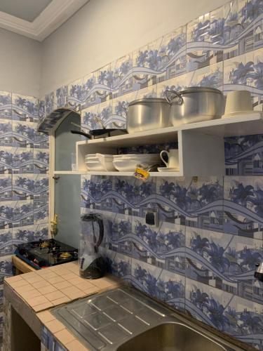 cocina con azulejos azules y blancos en la pared en Villa JFK2 en Uagadugú