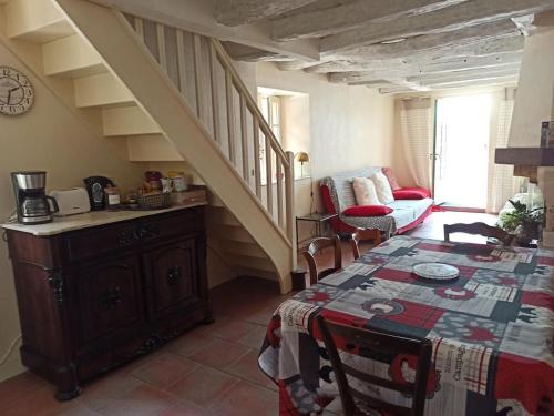 a living room with a table and a staircase at Gite 3 chambres, 2 à 10 pers et jardin clôturé in Oradour-sur-Glane
