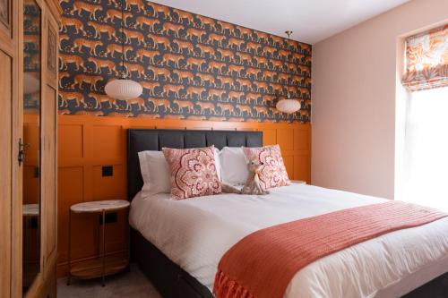 a bedroom with a large bed with a wall with birds on it at Apartments at Number 16 - The Jolly Coopers in Hampton