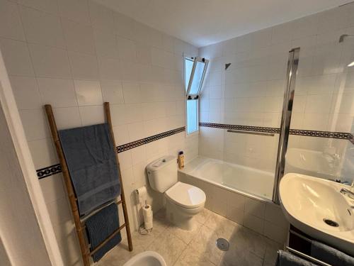 a bathroom with a toilet and a tub and a sink at Encantador apartamento frente al mar en Matalascañas: ¡Tu escapada perfecta! in Matalascañas
