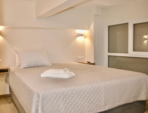a white bed with two towels on top of it at Piraeus Relax in Piraeus
