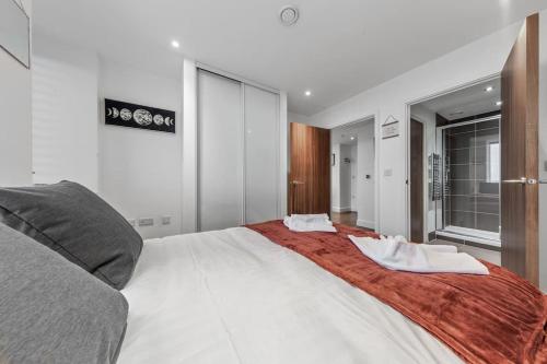 ein Schlafzimmer mit einem großen weißen Bett in einem Zimmer in der Unterkunft New Apartment in Britannia point BP4 in London