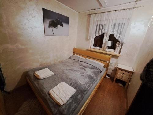 1 dormitorio con 1 cama con 2 toallas en Dom drewniany z ogrodem en Szczecinek