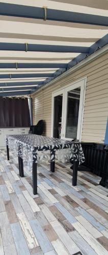 een bankje op een patio voor een huis bij Mobil home neuf 693 à la réserve 8 personnes avec terrasse couverte in Gastes