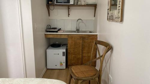 a small kitchen with a sink and a chair at EL Lingue II in Puerto Varas