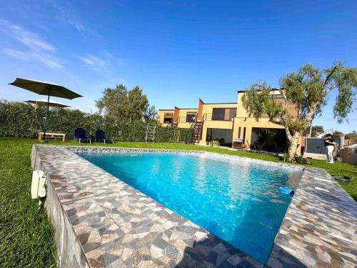 ein Pool vor einem Haus in der Unterkunft Terraviva Chincha® Casa de Campo Natural y hermosa in Chincha Baja