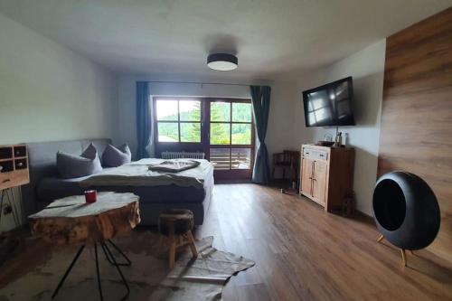 a bedroom with a bed and a table and a tv at Apartment in der Alpenresidenz mit einem faszinierenden Ausblick in Berchtesgaden