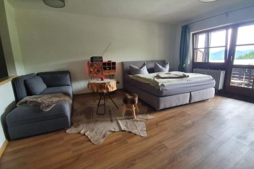 a bedroom with a bed and a couch and a chair at Apartment in der Alpenresidenz mit einem faszinierenden Ausblick in Berchtesgaden