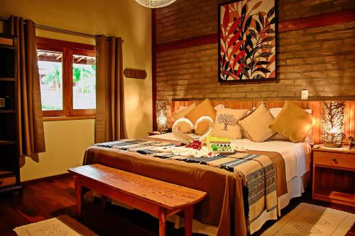 a bedroom with a bed and a table in it at Encantes do Nordeste in Barreirinhas