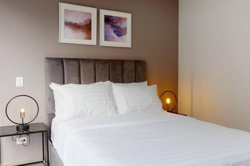 een slaapkamer met een groot wit bed met 2 lampen bij Apartamento 201 Kappa in Bogota