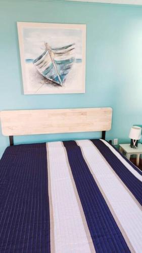 a bedroom with a bed with a painting on the wall at Beach Bliss, Great View in Guysborough
