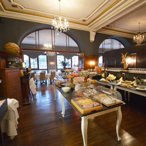 a large kitchen with a table with food on it at Hotel de la Poste - Relais de Napoleon III in Bouillon