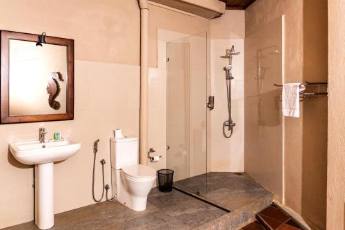 a bathroom with a shower and a toilet and a sink at Seahorse Hotel & Spa in Negombo