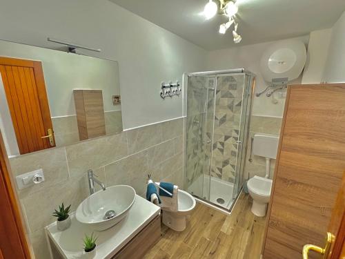 uma casa de banho com um chuveiro, um lavatório e um WC. em Lovely Apartment em Stintino