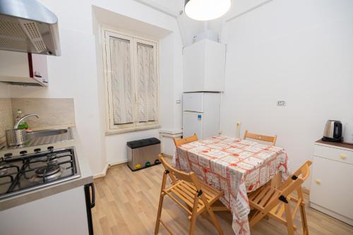 kuchnia ze stołem, krzesłami i lodówką w obiekcie Adriana sweet apartment w Rzymie