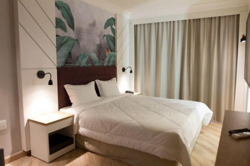 een slaapkamer met een wit bed en een raam bij Bristol International Guarulhos in Guarulhos