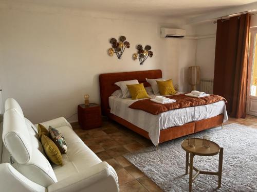 a bedroom with a bed and a couch at les petites terrasses in Grasse