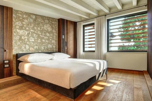 een slaapkamer met een bed en een groot raam bij 5 Terrazze Exlusive Apartments in Gargnano