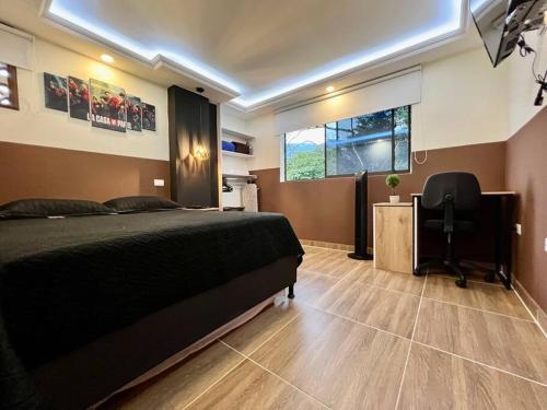 1 dormitorio con cama, escritorio y ventana en 402 GTA Sandreas / la casa de papel, en Medellín