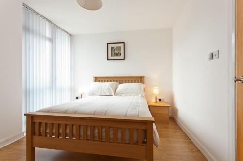 a bedroom with a large bed with white sheets at Luxury ground floor 2 Bedroom apartment Bangor. in Bangor