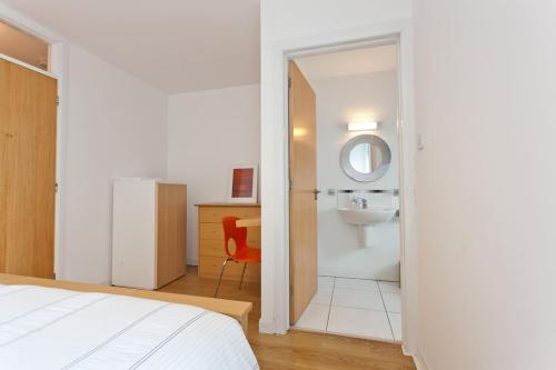 a bedroom with a bathroom with a sink and a mirror at Luxury ground floor 2 Bedroom apartment Bangor. in Bangor