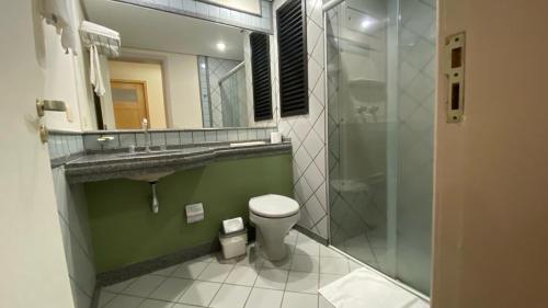 a bathroom with a toilet and a sink and a shower at Hotel Solarium Express in Cambé