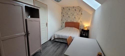 a small bedroom with a bed and a table at La Grange in Woignarue