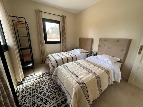 - une chambre avec 2 lits et une fenêtre dans l'établissement Harmonie des alizés, à Essaouira