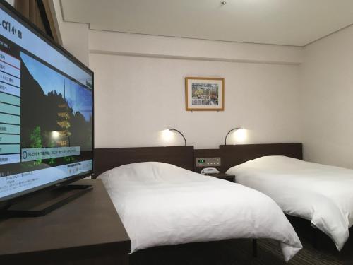 Schlafzimmer mit einem großen TV und einem Bett in der Unterkunft Hotel Alpha-One Ogori in Yamaguchi