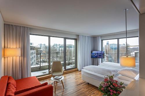 um quarto com uma cama e uma grande janela em Pestana Berlin Tiergarten em Berlim