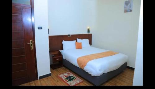 a bedroom with a bed and a wooden door at Obelisk Hotel Axum in Āksum