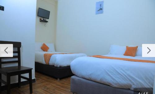 a hotel room with two beds and a tv at Obelisk Hotel Axum in Āksum