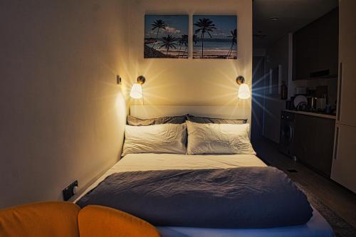 a bedroom with a bed with two lights on the wall at Stylish Studio Retreat in Dubai