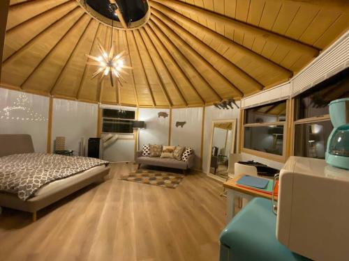 Glamping-Sky Dome Yurt-Tiny House-2 by Lavenders field في Valley Center: غرفة نوم بسرير واريكة في غرفة