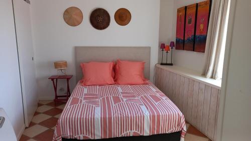 1 dormitorio con 1 cama con almohadas rosas en Rabbit House Gite, en Singleyrac