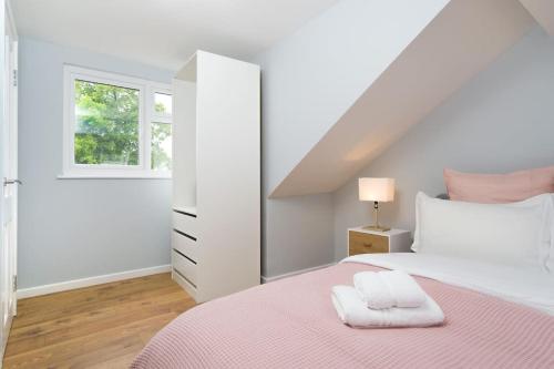 a white bedroom with a bed and a window at Delphina - Spacious 2BR Modern Maisonette in London