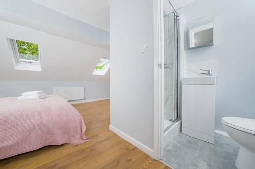 a white bathroom with a bed and a sink at Delphina - Spacious 2BR Modern Maisonette in London