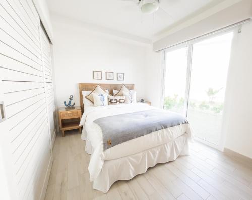 1 dormitorio blanco con 1 cama grande y ventana grande en Residences by Playa Caracol Residences en El Quindio